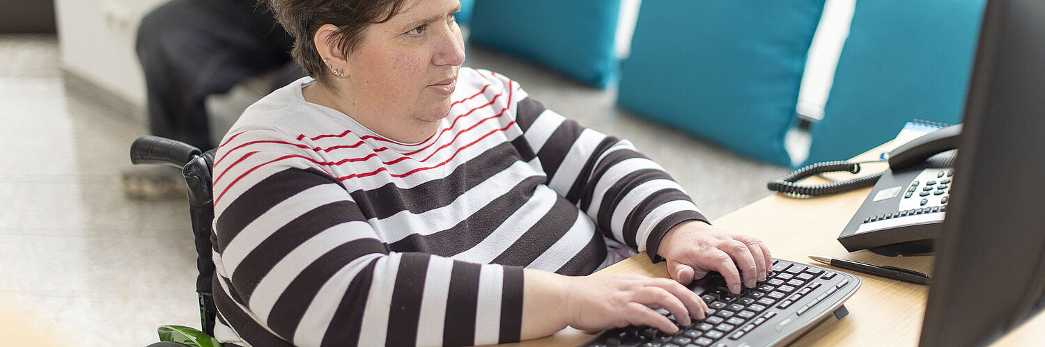 Das Bild zeigt eine Mitarbeiterin die auf einer Tastatur schreibt.