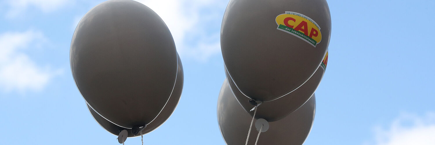 Das Bild zeigt Luftballons mit CAP Logos.